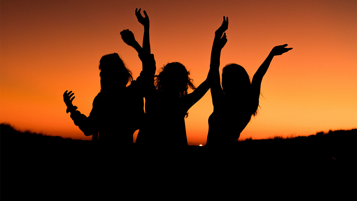 Drei Frauen tanzen im Sonnenuntergang
