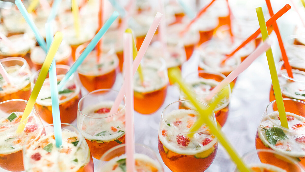 Viele Cocktail Gläser mit Früchten und Strohhalmen